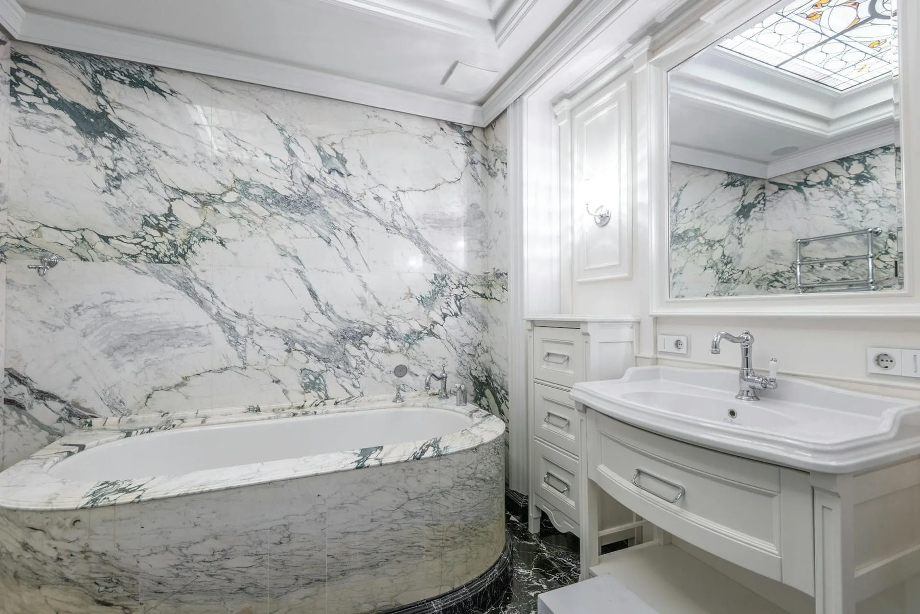 Marble bathroom installation with bookmatched slabs