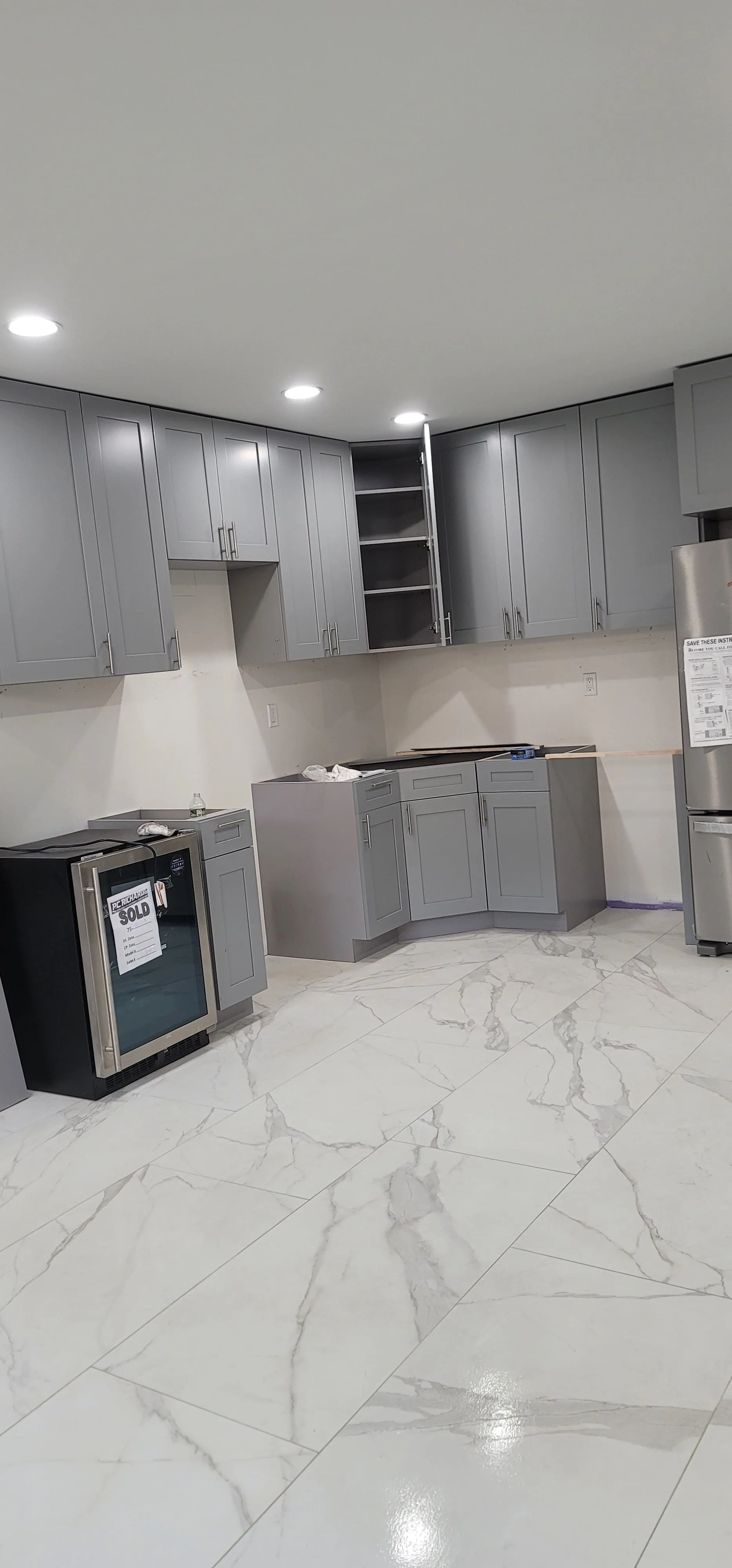 High-end modern kitchen remodel with custom cabinetry and marble waterfall island