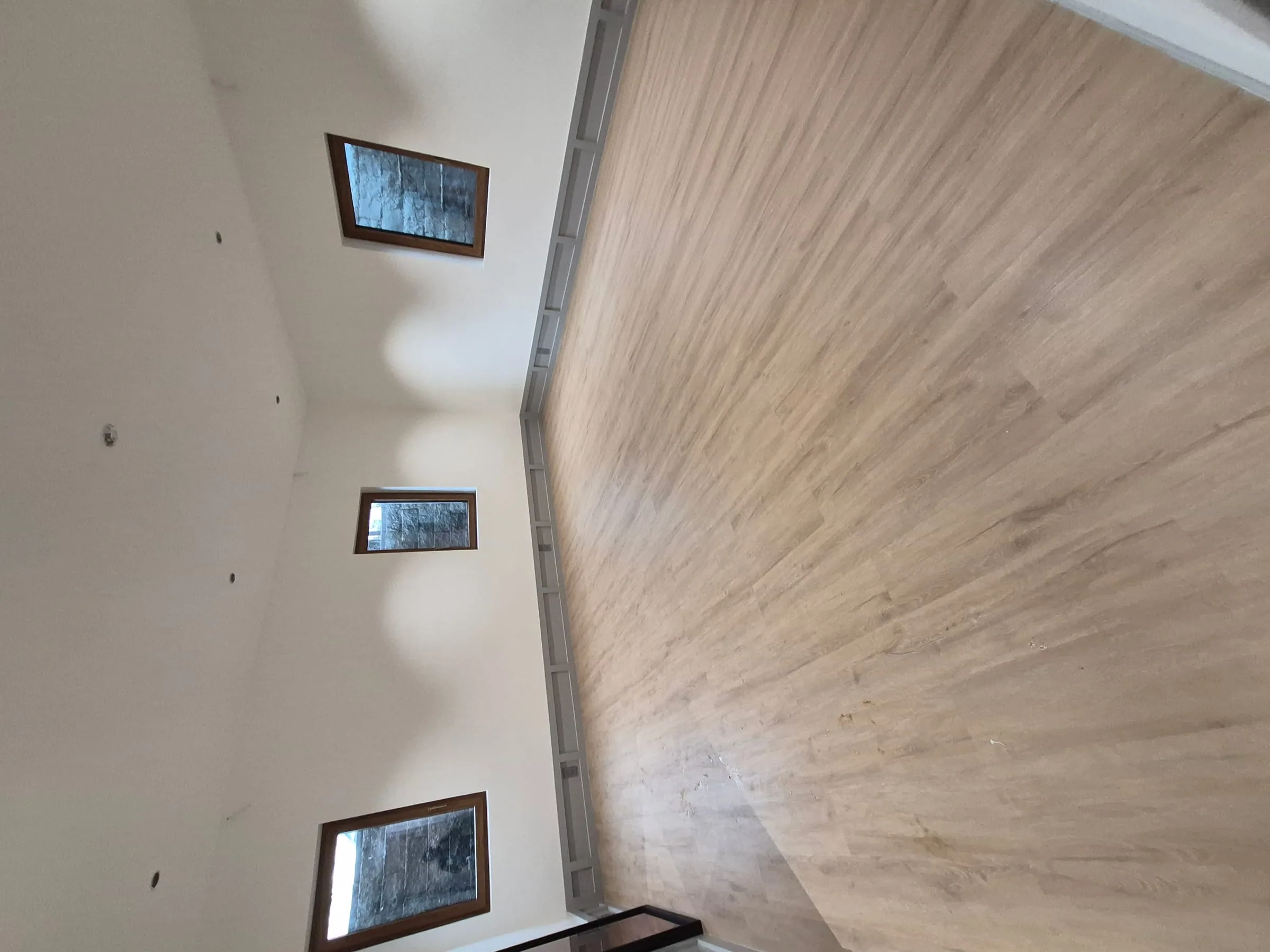 Single-room apartment install — wide-plank engineered wood flooring set inside one room of a NYC apartment scope